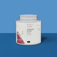 Minimalistischer weißer Teebehälter mit rotem Blattmotiv und der Aufschrift GOLDEN EARL Schwarztee Nr. 051.