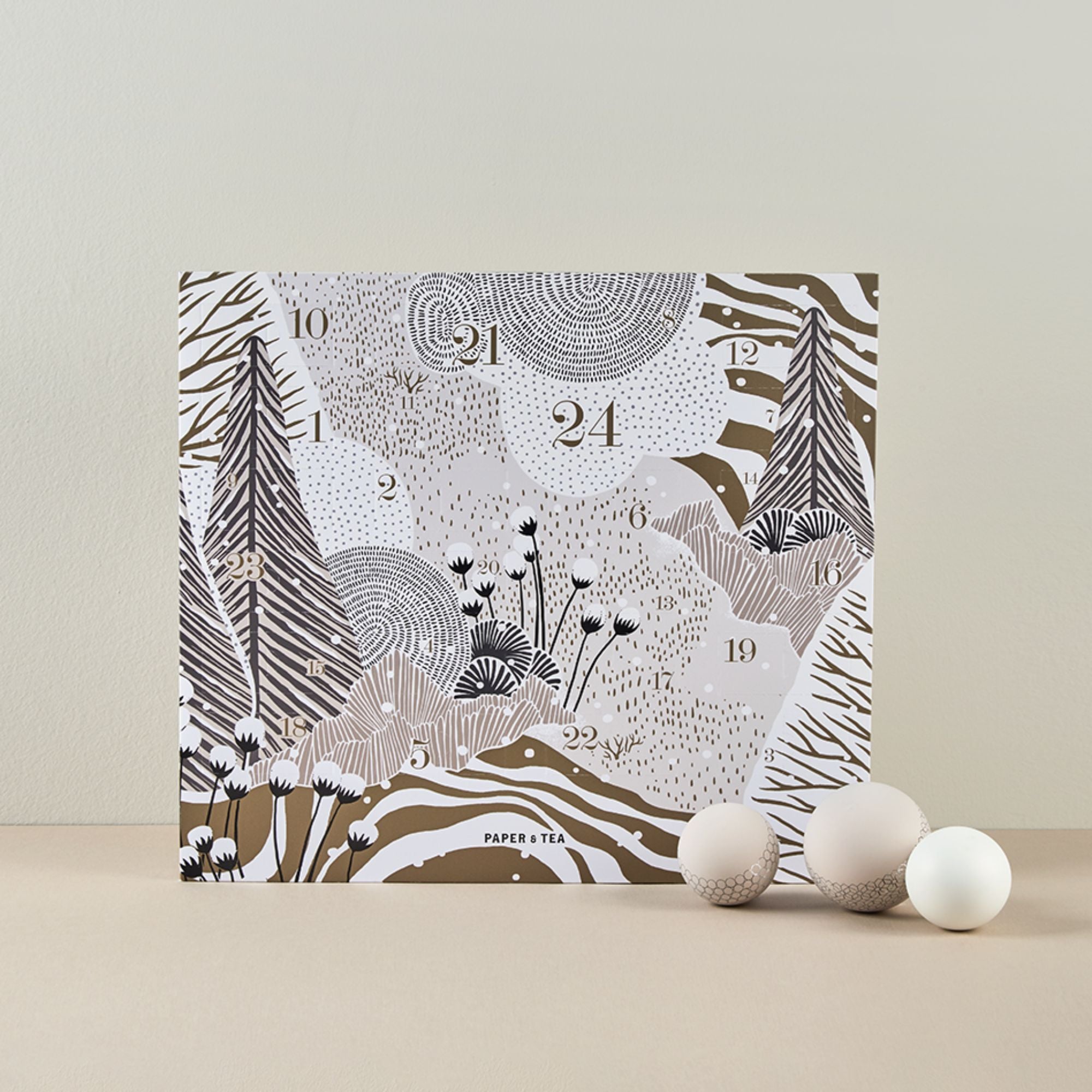 Paper & Tea Adventskalender mit Naturmotiv in Braun- und Beigetönen, verziert mit Kugeln.